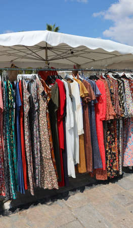 Clothes for sale at outdoor market stand in summerの写真素材