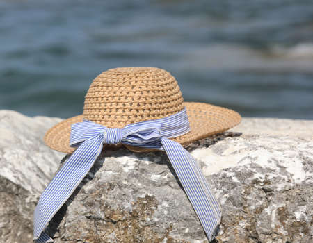 straw hat on a rock by the sea, symbol of holidays and travel and vacationsの写真素材