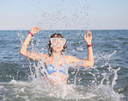 young girl with diving mask plays the stinking water in the summer in the sea amusesの写真素材