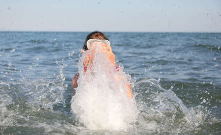 young girl with diving mask plays the stinking water in the summer in the middle of the sea having a great timeの写真素材