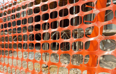 orange plastic net for the protection of the construction site during the construction of a building with materials for the safeguard of energy savingの写真素材