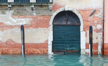 door of the entrance to a house completely flooded at high tideの写真素材