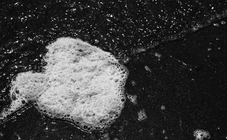 white foam of sea pollution with black and white effectの写真素材