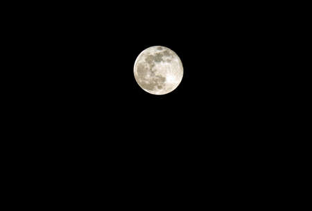 perfect full moon at midnight on black sky with visible cratersの写真素材