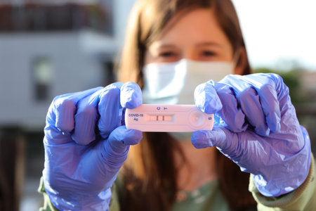 female doctor showing the rapid test with two lines indicating the diagnosis of positive Covid-19 virusの写真素材