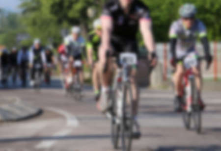 intentionally blurred background with cyclists pedaling fast on the bicycles during the road cycling raceの写真素材