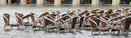table and chairs of the alfresco cafe under water in Piazza San Marco during a terrible flood in the island of Venice in Italyの写真素材