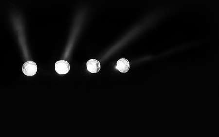 four powerful stage spotlight on the black background without people ideal as a concert backdropの写真素材