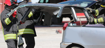 firefighters as they remove the hood of a car damaged after the road accident on the motorway