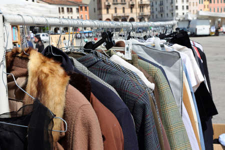 alfresco flea market in the public park and the coats and furs and other used clothes in the vintage clothing stallの写真素材