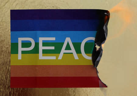 large banner with the word peace and fire burning it symbolizing war that destroys forever on golden backgroundの写真素材