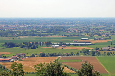landscape of Wide flatland called Pianura Padana in italian language in Northern Italty with Farm and cultivated fieldsの写真素材