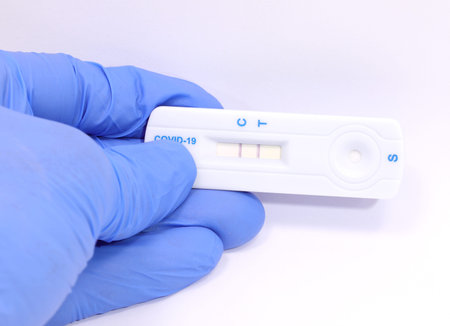 Glove showing positive result with two lines of antigen test to detect  from salivary sample and...