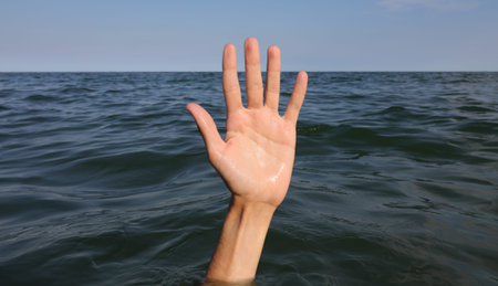 hand with five fingers sticking out of the sea surface that looks healthy or looks like the person...