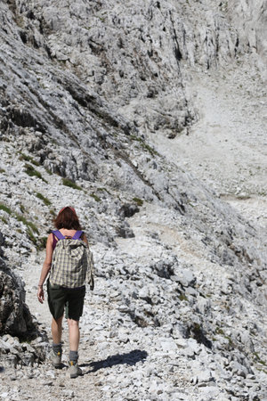 Young woman walks on the trail of the Dolomites in the European Alps of the mountain range called Pale Group in Italyの写真素材