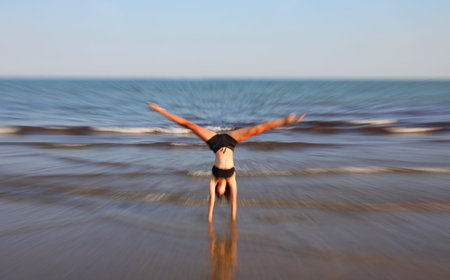 slim athletic girl performs gymnastic exercises in summer