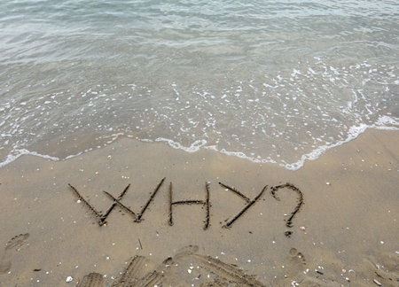 LARGE capital letters text WHY on the sand of the beachの写真素材