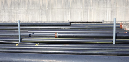 black plastic pipes in the store of building material on the road construction site