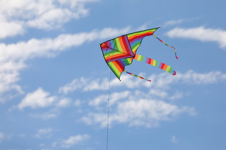 colorful kite with the multi colors of the rainbow flies freeの写真素材