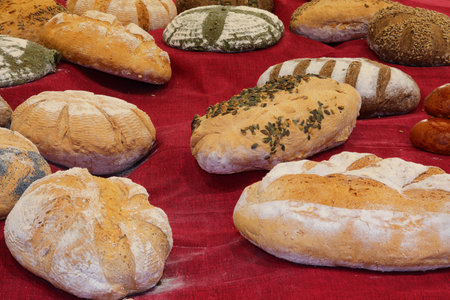 many loaves of bread made with mixed flour and seeds freshly baked by the baker in the bakery