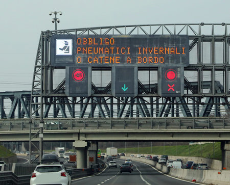 Wide Signal in the Motorway with text that means obligation winter equiment or chains snow in...