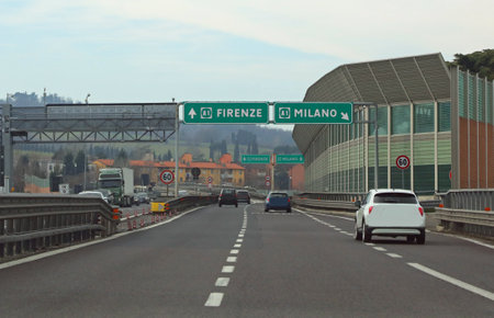 Wide italian Road Signal at crossroad with name of City MILAN and Florence in Central Italyの写真素材