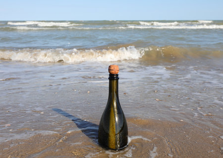 Bottle of green green on the shore of the sea without people with cork capの写真素材