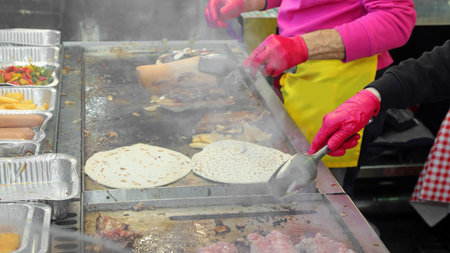 Cook during the preparation of the takeaway food cooked on a hot plate during the village festivalの写真素材