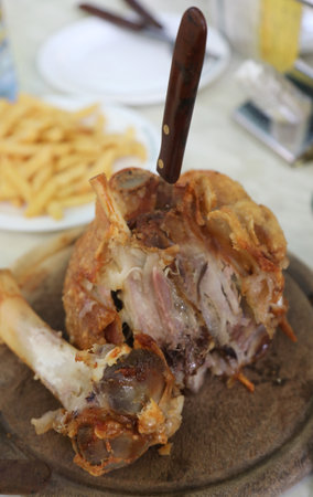 baked pork knuckle and a knife and the big pork boneの写真素材