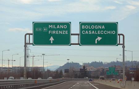 road sign with directions to reach Milan - Florence or Bologna and the crossroads in central Italy with very few carsの写真素材
