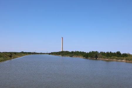 Porto Tolle, RO, Italy - July 5, 2023:Chimney of thermoelectric plant to produce electric energy and Po River in Italian plainのeditorial素材