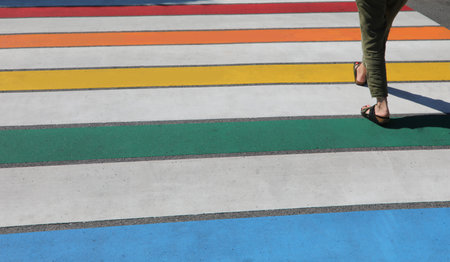 multicolored stripes with rainbow colors of crossing people and the feet of people walkingの写真素材