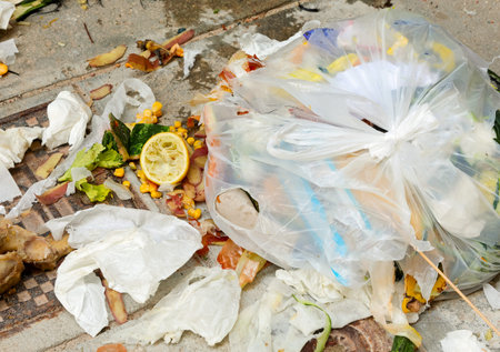 broken garbage bag abandoned on the street with all things scattered on the ground sign of...