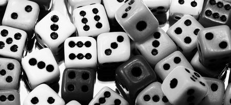 background of mini cubic six-sided gaming dice rolled for playing with black and white effect
