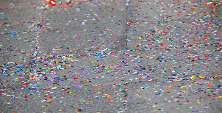 colorful background of many multicolored paper confetti on the city floor after partyの写真素材