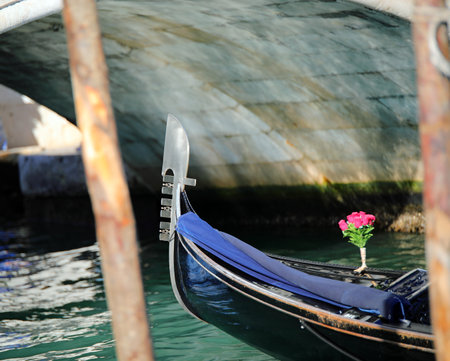 Bow of gondola the traditional Venetian boat for transporting tourists and pot of flowers in the grand canalの写真素材
