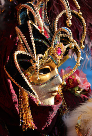 Venice, VE, Italy - February 13, 2024: person with a highly decorated ancient court jester mask at the Venetian carnivalのeditorial素材