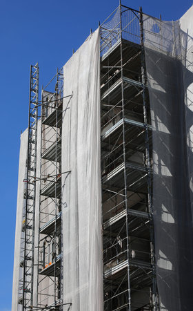 Construction scaffolding of a high-rise building with many apartments during the installation of...
