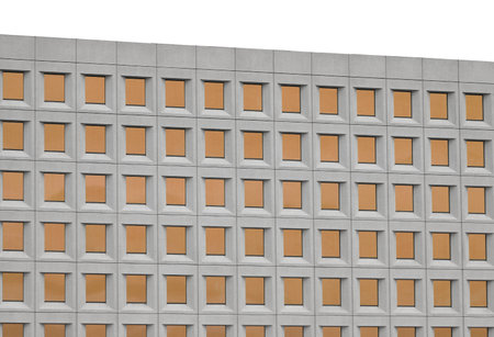 Modern concrete and glass building reflecting the orange of the sunset arranged in a neat grid