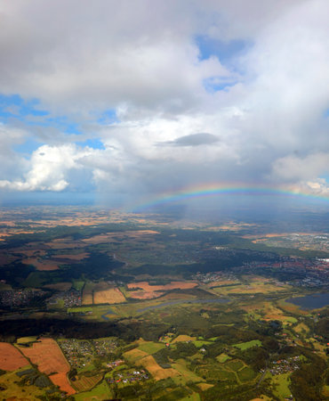 amazing view of the rainbow from above and the plain and the white clouds photographed from the plane in flightの写真素材