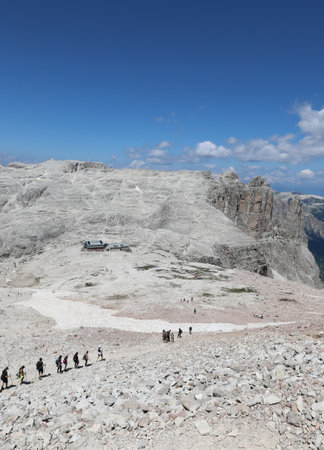 tiny people looking like ants as they walk along the rocky trail of the mountains in the European Alps in Northern Italyの写真素材