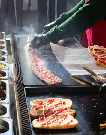 preparation of many stuffed sandwiches at a street food stand on a hot griddleの写真素材