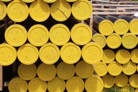 many yellow plastic caps of the large pipes for the transport of methane gas in the building material depotの写真素材