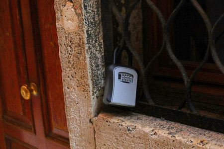 small container for safe storage of keys to the rental apartment with secret code combination for opening near the entrance of the houseの写真素材