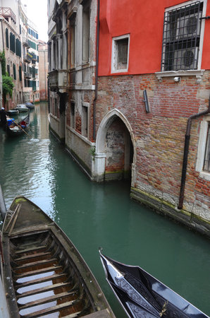 view of the narrow navigable canal in Venice in Italy and the boats and gondolasの写真素材
