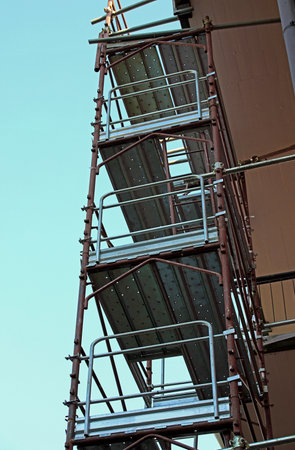 iron scaffolding from the construction site installed on the condominium during maintenance work on the buildingの写真素材