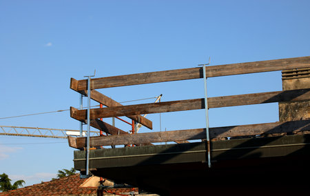 detail of the barrier with wooden planks firmly installed on the roof for the protection of workers to avoid falls during the roof repair work of the condominium without peopleの写真素材