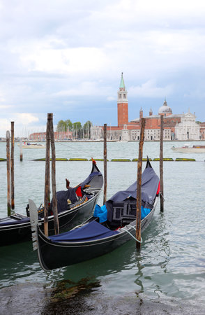 moored gondolas the typical boats in venetian Lagoon in VENICE In Northern Italy and Church of St.Georgeの写真素材