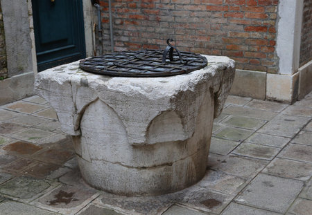 ancient stone well used to draw rainwater in the streets of Venice in northern Italyの写真素材