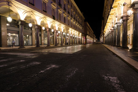Night view of the road called VIA ROMA in Turin City in Northern Italy with many arcades and large shop windowsの写真素材